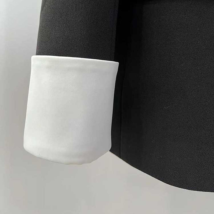 Detail of one button white collar blazer for women showcasing a white cuff on a black sleeve