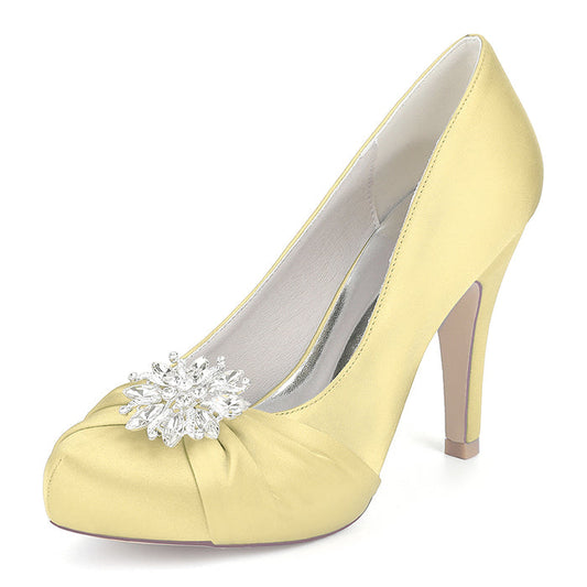 Yellow high-heeled shoe with a decorative flower on a white background