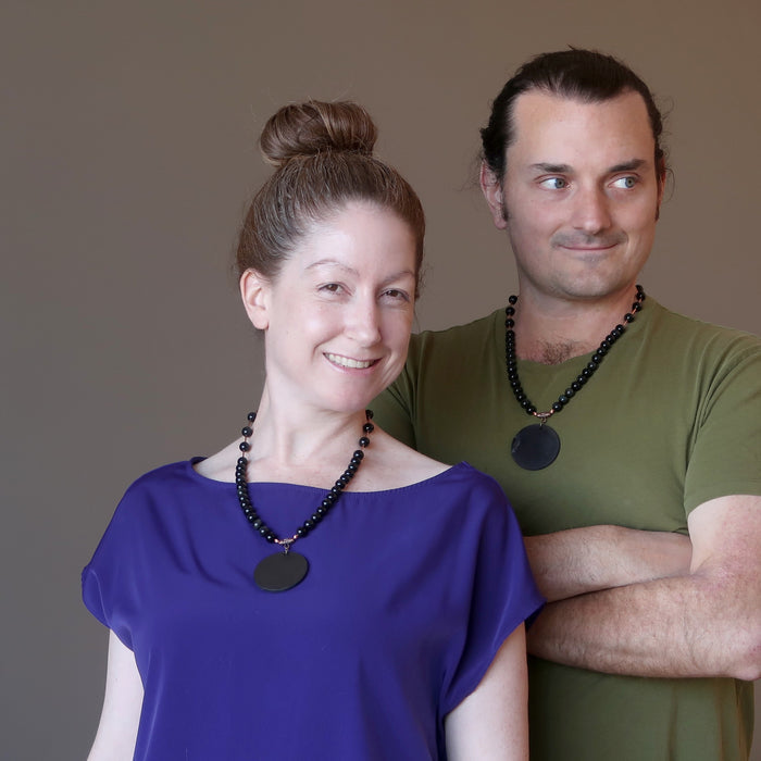 couple wearing shungite rainbow obsidian necklaces