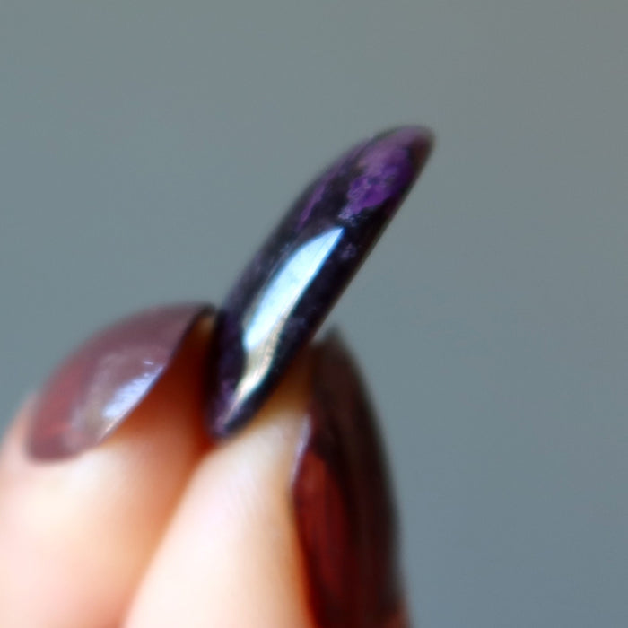 fingers holding Sugilite Polished Stone