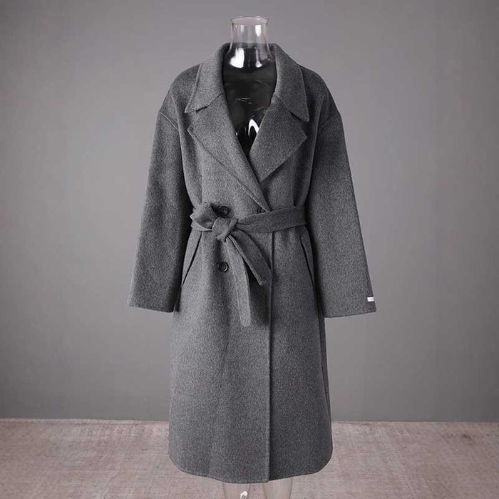 Stylish women's double-breasted grey coat with a belted waist and oversized lapels