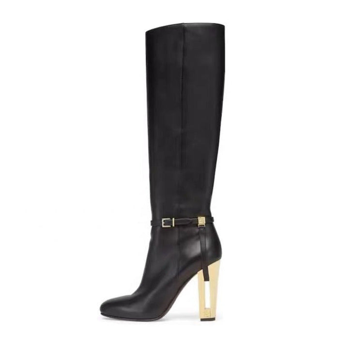 Black knee-high boot with a gold heel on a white background