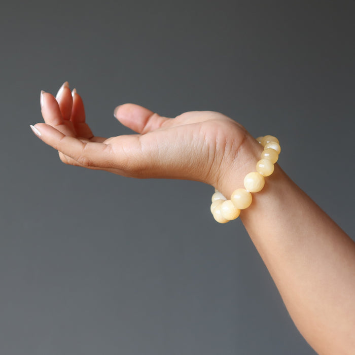 hand wearing a yellow calcite beaded stretch bracelet