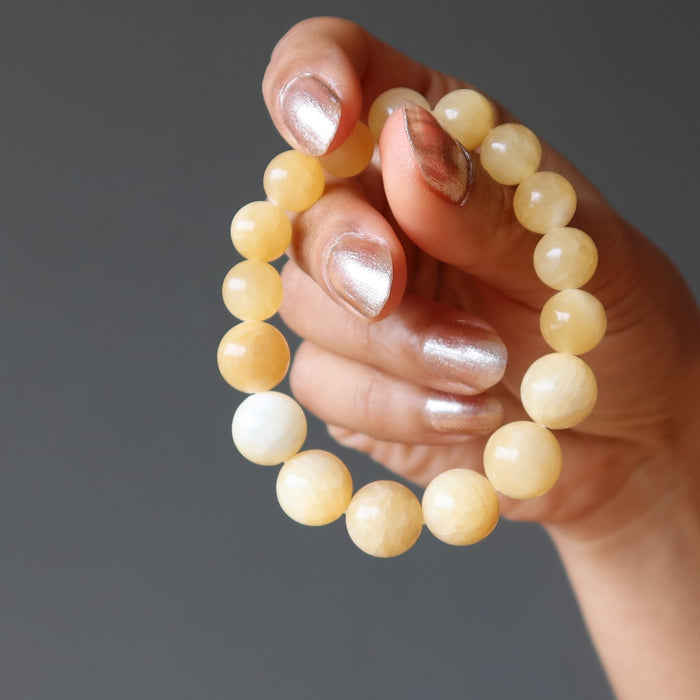 hand wearing a yellow calcite beaded stretch bracelet